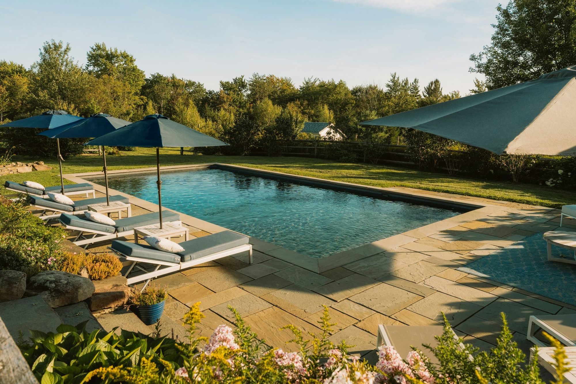 Piscina com guarda-sóis e espreguiçadeiras